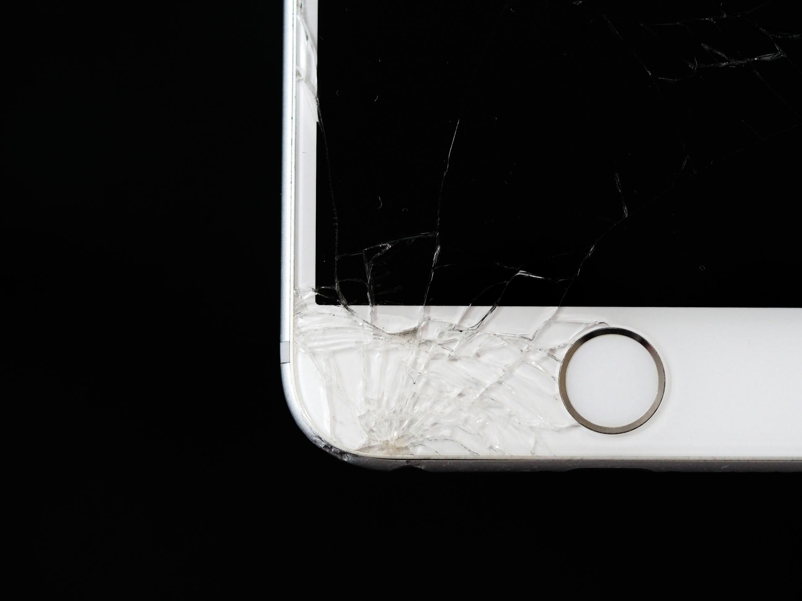 Detailed image of a cracked iphone screen highlighting damage to the device.